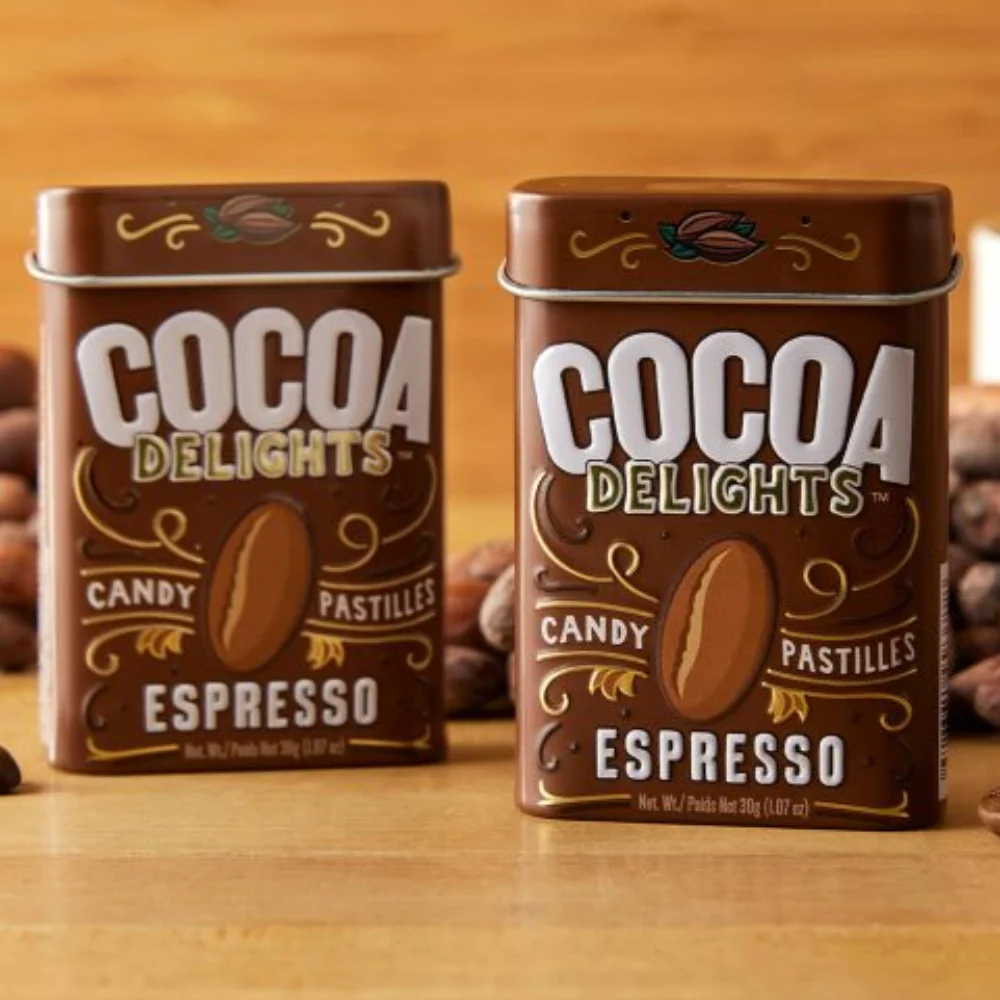 Two tins of Big Sky Mints Cocoa Delights Espresso placed on a bed of coffee beans, emphasizing the espresso flavor.