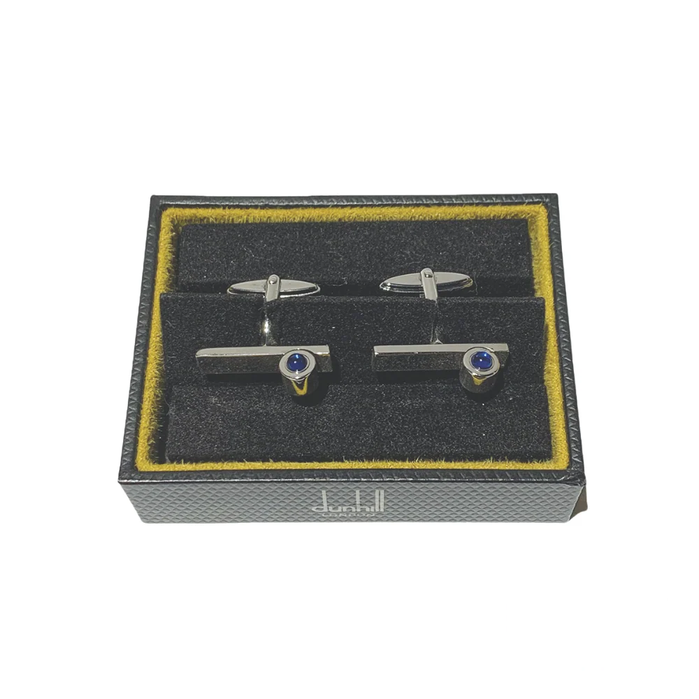 Stylish Blue Ruby Dunhill cufflinks captured from a top view, showcasing the intricate detailing and luxurious blue gemstones embedded in a sleek metallic finish.