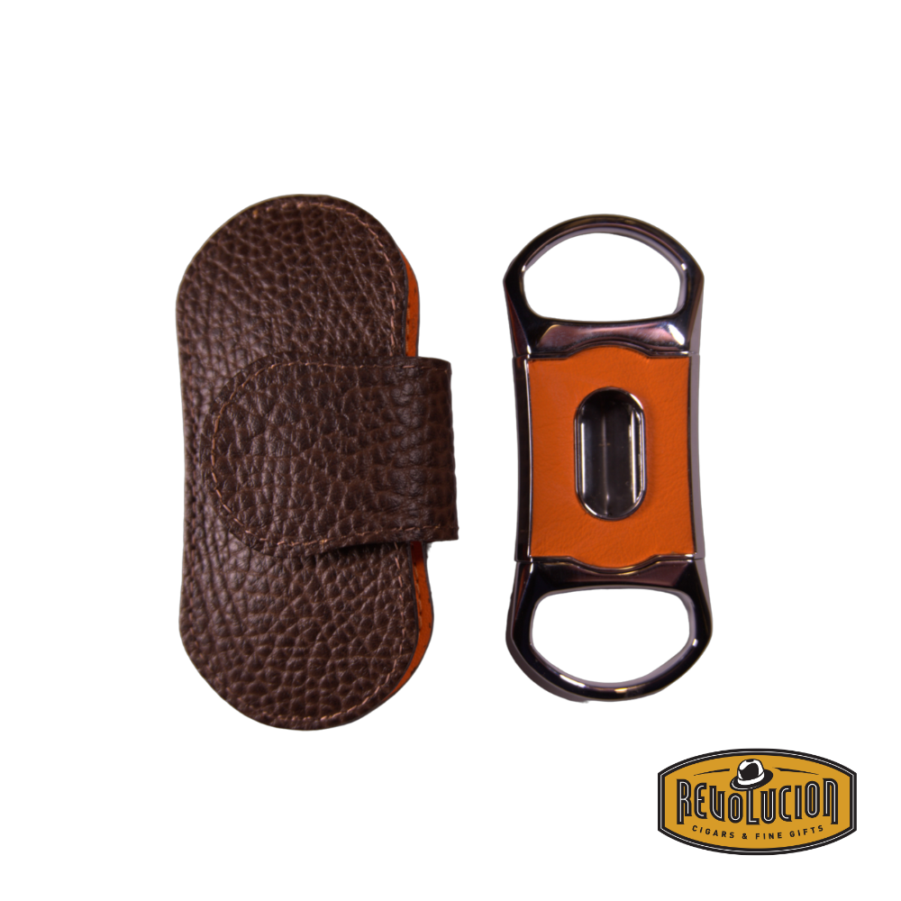 Brizard & Co. "V" Cigar Cutter - Orange next to its elegant leather case, featuring a vibrant orange leather design with a sleek metal frame for a sophisticated cigar-cutting experience.
