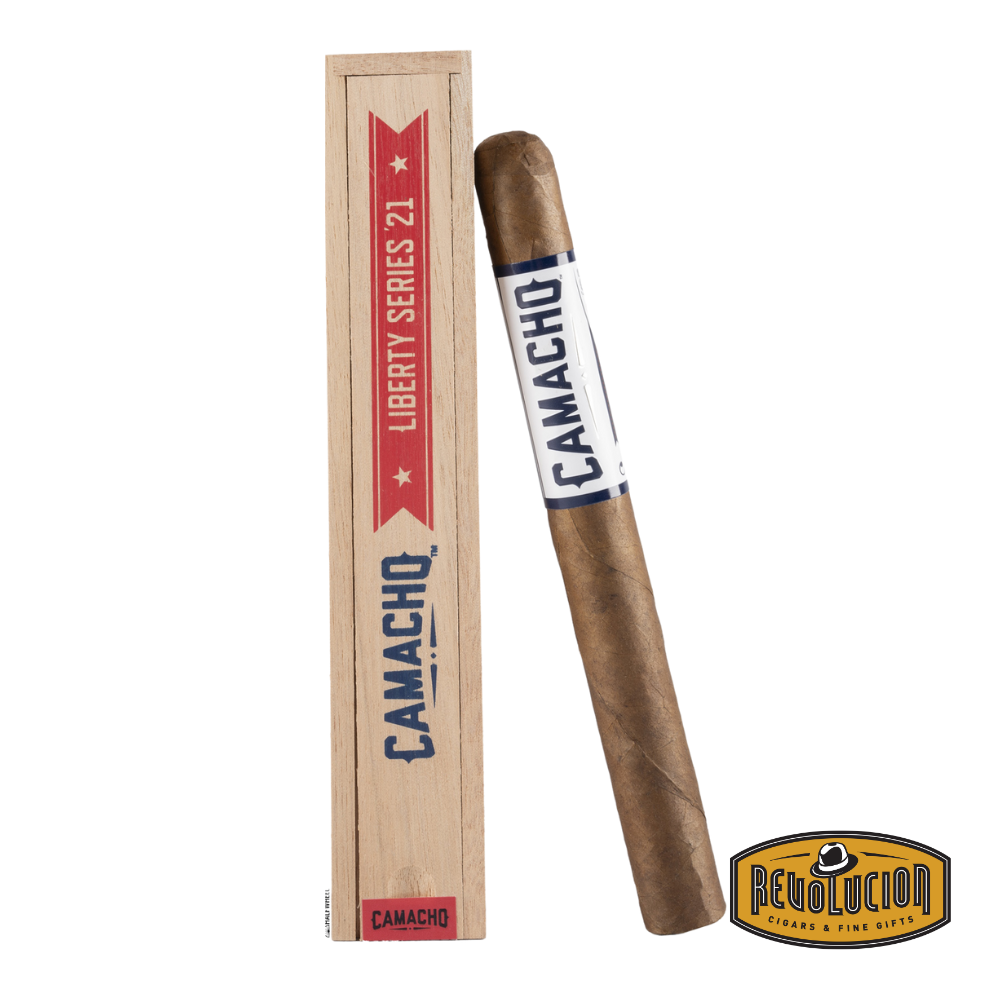 Camacho Liberty 2021 Churchill Medium-Full Strength Honduran Cigar resting on a white background with the Revolucion logo.
