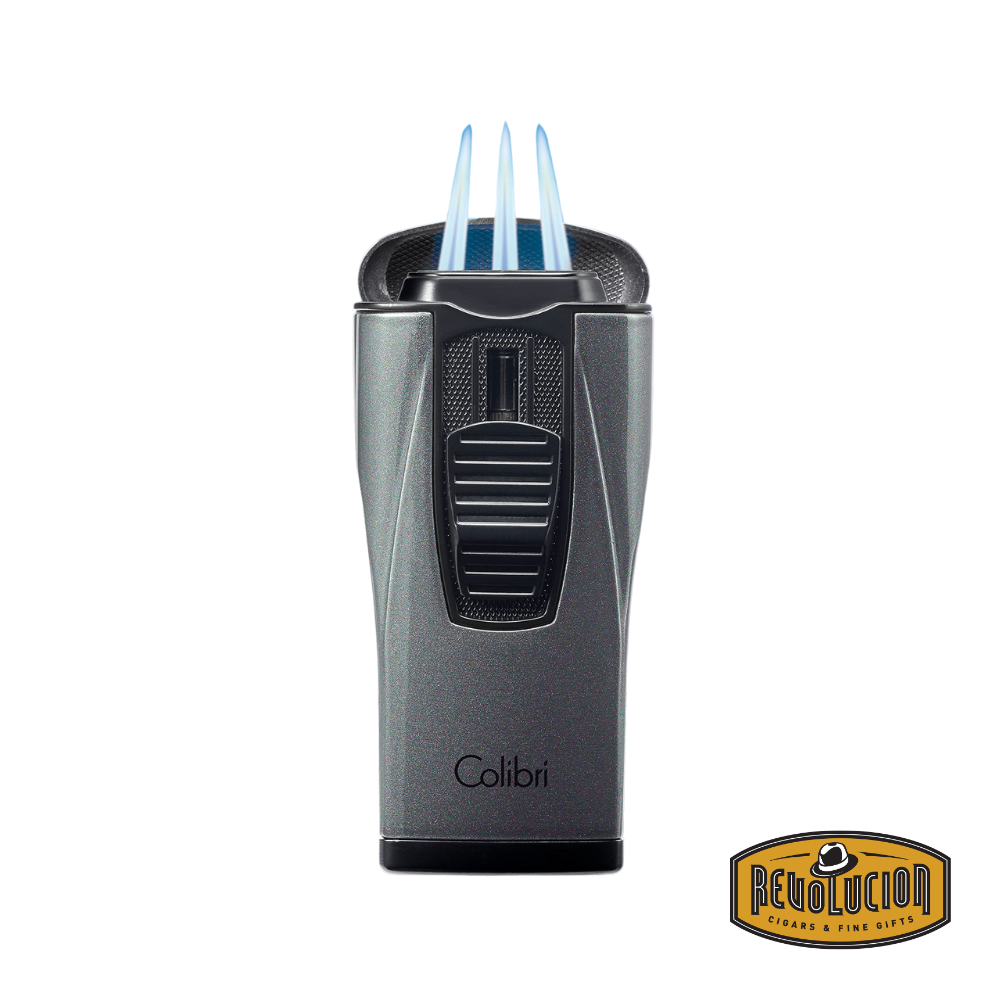 The Colibri Monaco Triple Jet Cigar Lighter in Metallic Charcoal ignited, revealing its three powerful blue flames for an even and precise burn.