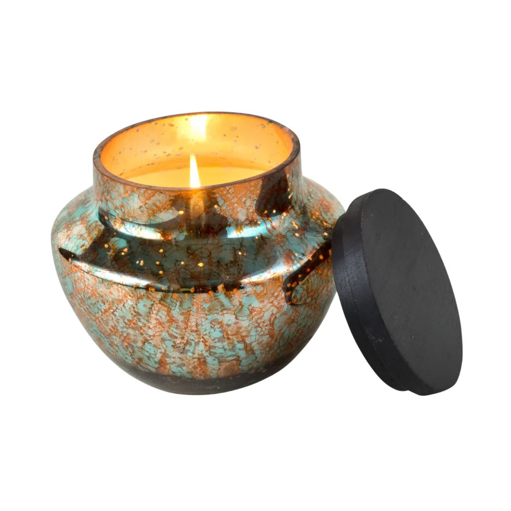 Himalayan Handmade Candles - Watercolor Glass in Turquoise & Copper, Sunlight in the Forest scent, 16 OZ candle lit and glowing.