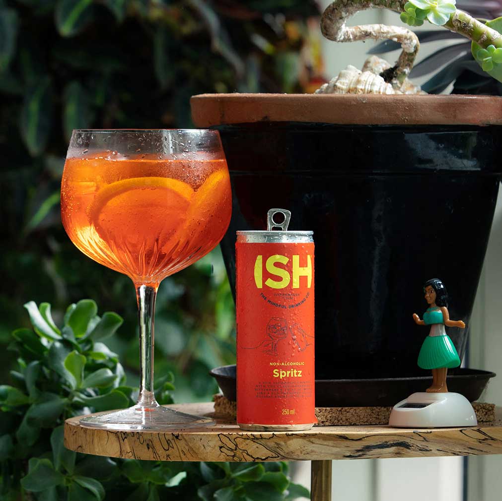 A 250 ml can of ISH Spritz Non-Alcoholic Cocktail beside a mocktail cup, showcasing the drink's crisp, citrusy essence perfect for alcohol-free celebrations.