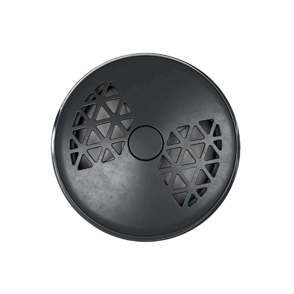 The photo shows the front of the Maison Berger Smart Car Diffuser, featuring a sleek and modern design in tones of black and gunmetal. The device has small triangular openings that form a geometric pattern reminiscent of a bowtie. The device is turned to the left, indicating a lower fragrance intensity.