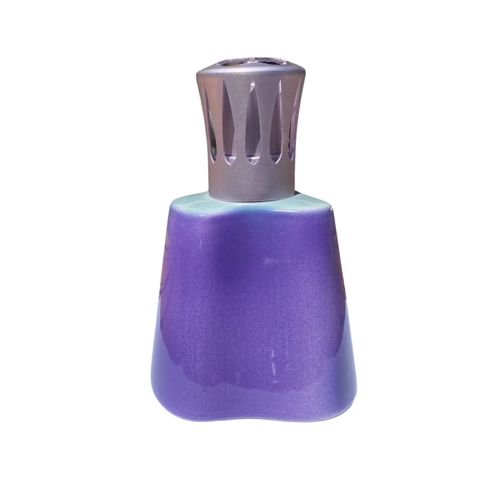 Lampe Berger Island Parme lamp featuring a soft, gradient finish of purple and turquoise with a metallic cutout diffuser cap, displayed on a white background with Revolucion logo.