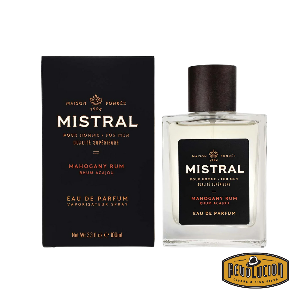 Mistral Mahogany Rum Eau De Parfum – A luxurious men's fragrance blending warm mahogany with the rich, spiced aroma of aged rum. Housed in an elegant glass bottle with a dark wood cap and stylish black packaging.