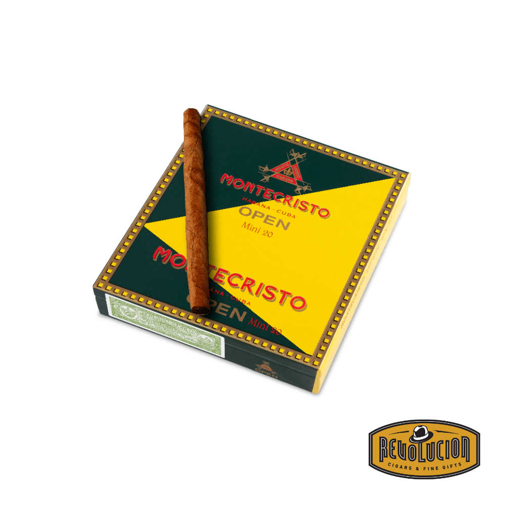 A Montecristo Open Mini mild-strength Cuban cigarillo placed in front of its original closed box, showcasing its compact size and smooth wrapper.