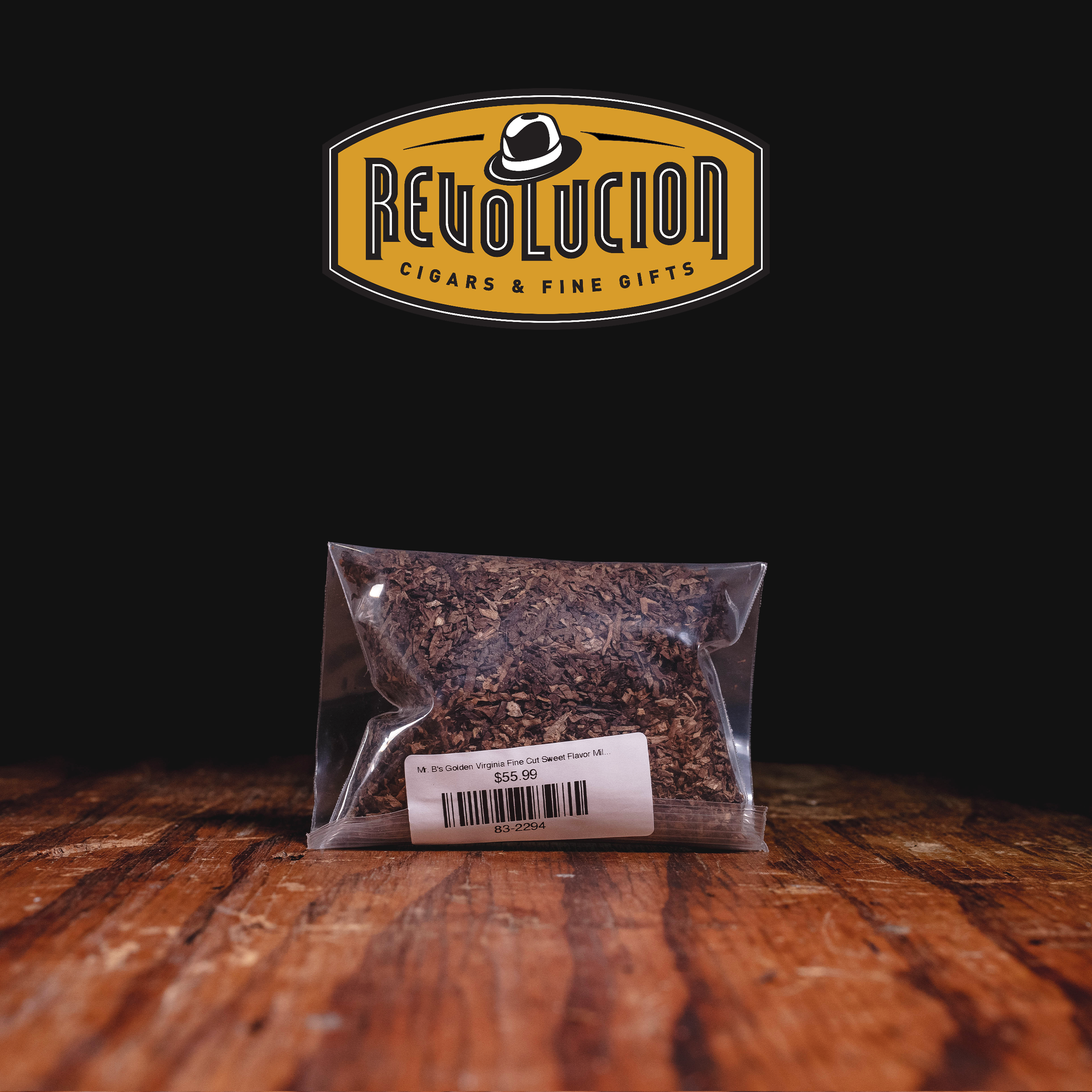A bag of "Mr. B's Golden Virginia Fine Cut Sweet Flavor Mild" tobacco with a price tag of $55.99, set against a dark background with the "Revolucion Cigars & Fine Gifts" logo above.