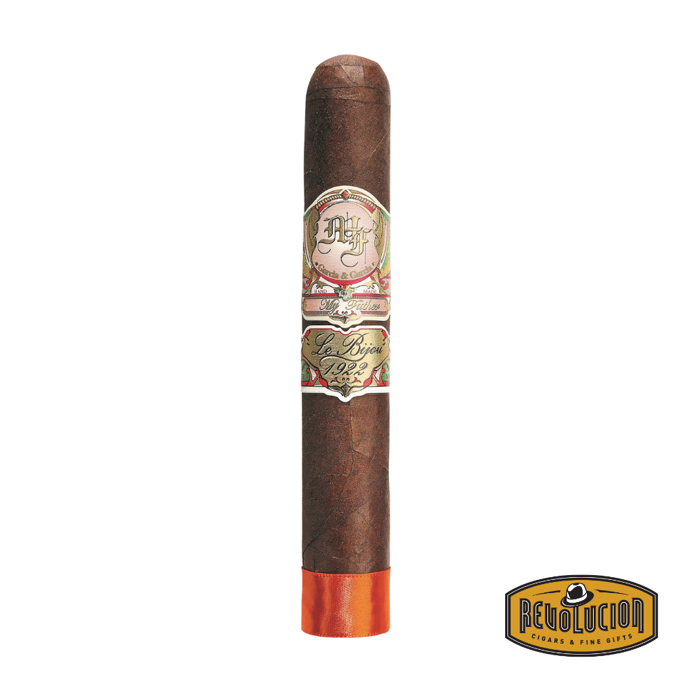 My Father Le Bijou 1922 Grand Robusto cigar resting on a wooden tray, with its signature dark wrapper and ornate band clearly visible.