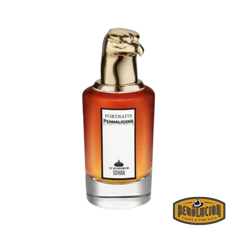 A close-up of Penhaligon’s The Uncompromising Sohan Eau de Parfum bottle, showcasing its deep red glass, elegant gold detailing, and distinctive gold peacock head cap.