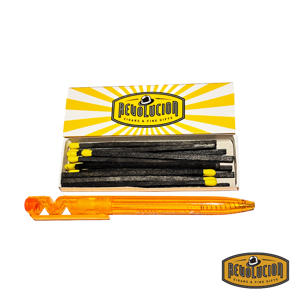 An opened box of 4" Revolucion matches revealing neatly arranged wooden matches, placed beside a pen for size reference.