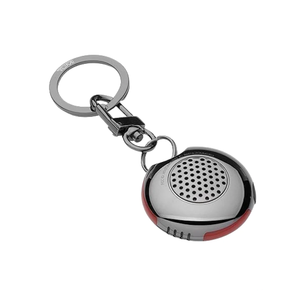 Tumi Smart Luggage Tracker device showing sleek compact design with button and branding visible.