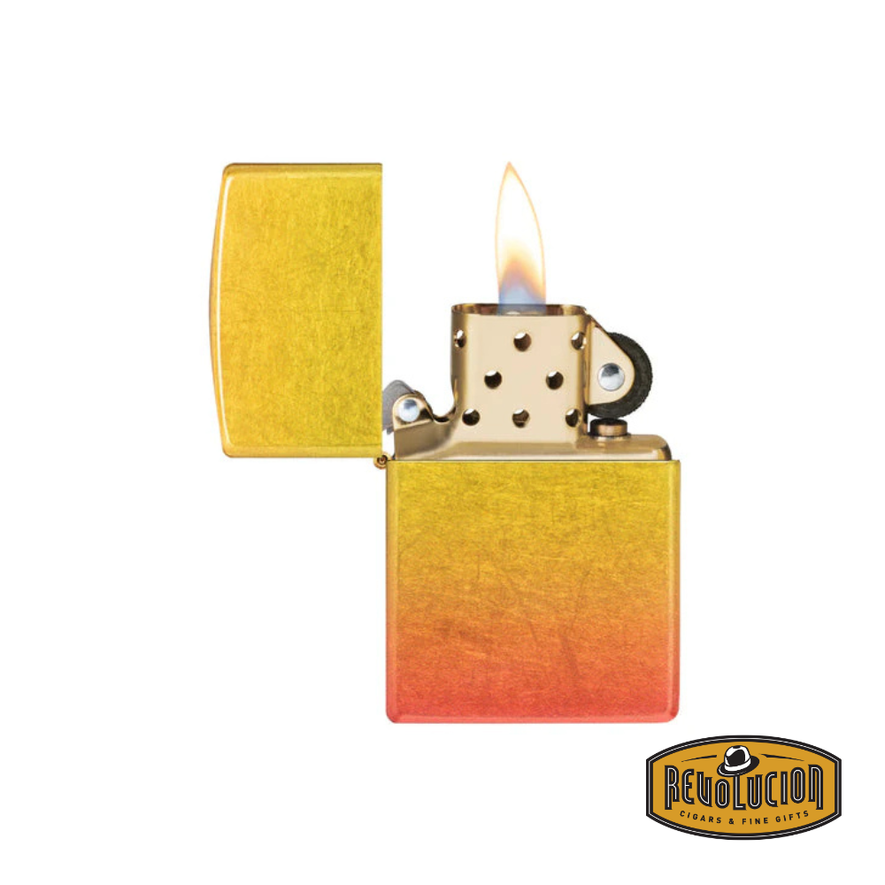 A Zippo lighter with a yellow-to-orange ombre gradient, opened to reveal its classic metal chimney and producing a flame. The Revolucion Cigars & Fine Gifts logo is displayed in the bottom right corner.