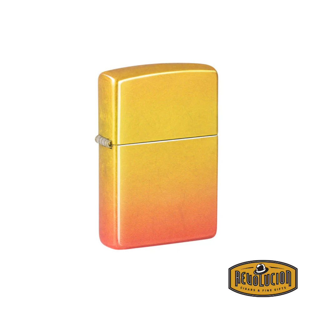 A closed Zippo lighter featuring a vibrant yellow-to-orange ombre gradient finish. The Revolucion Cigars & Fine Gifts logo appears in the bottom right corner.