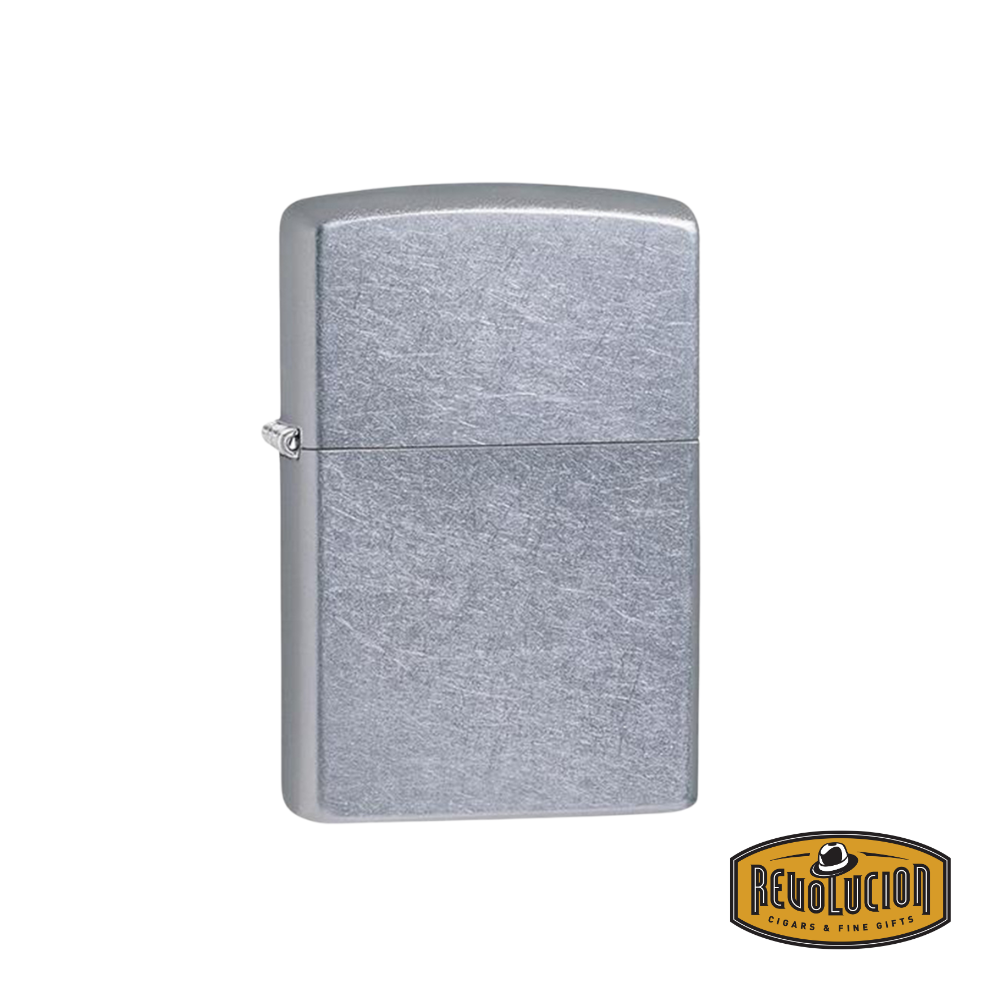 A Zippo Vintage Chrome Lighter with a classic, slightly aged chrome finish. The durable windproof design reflects timeless style. The Revolucion Cigars & Fine Gifts logo is positioned in the corner.