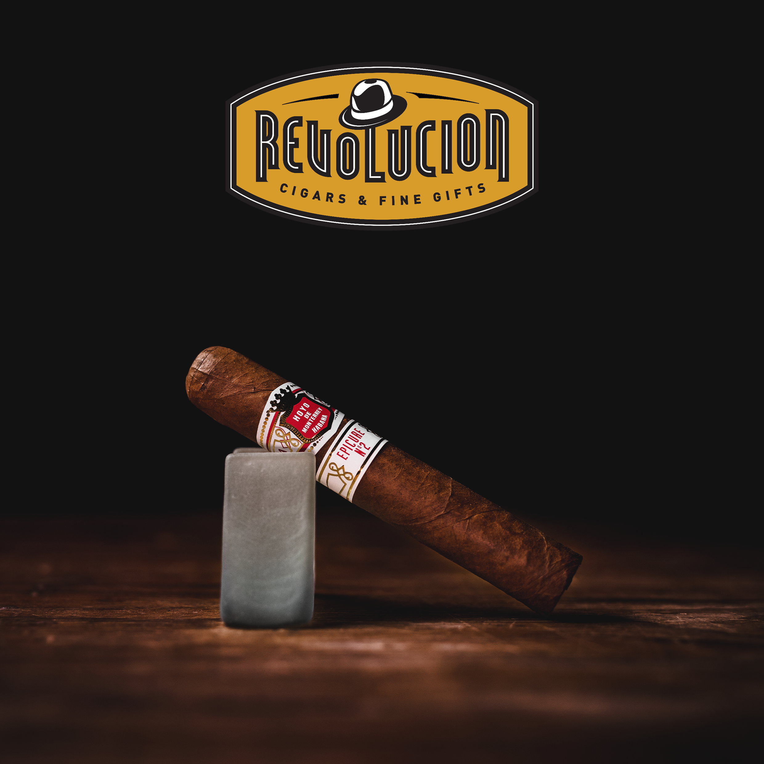 A Hoyo de Monterrey Epicure No.2 Cuban cigar displayed at an angle, showcasing its light brown wrapper, smooth texture, and elegant red-and-white band.