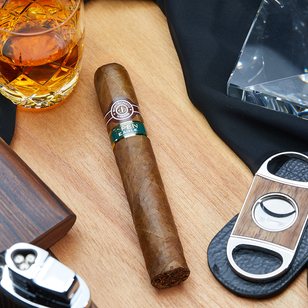 Montecristo Open Eagle Cuban Cigar - Front View: A Montecristo Open Eagle cigar with a smooth brown wrapper and the signature green and gold Open Series band, showcasing its premium Cuban craftsmanship.