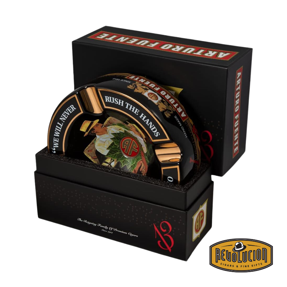 Arturo Fuente &#39;Journey Through Time&#39; Ashtray in Black, elegantly packaged in a branded box, showcasing the iconic Arturo Fuente artwork and gold cigar grooves, displayed with the Revolucion Cigars &amp; Fine Gifts logo.