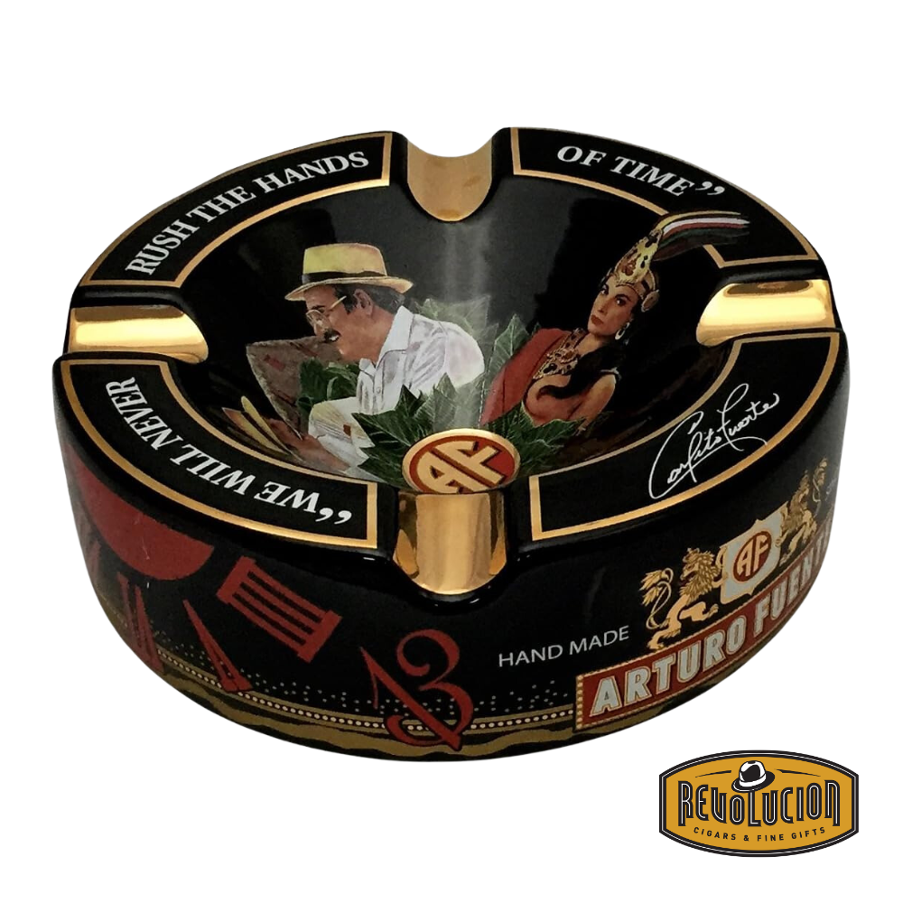 Arturo Fuente 'Journey Through Time' Ashtray in Black, featuring a vibrant design with four gold cigar grooves and iconic Arturo Fuente artwork, displayed with the Revolucion Cigars & Fine Gifts logo.