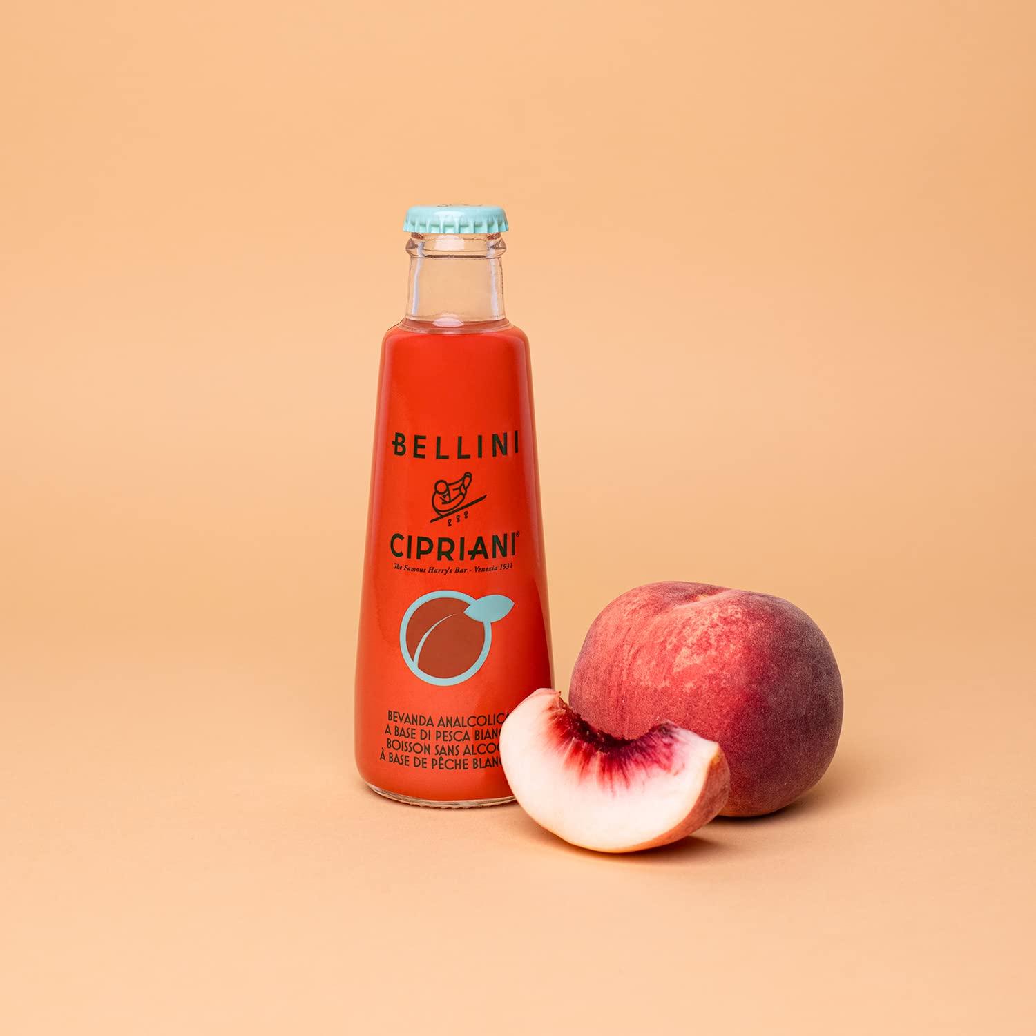 Cipriani Alcohol-Free Bellini Peach 180 mL bottle with a fresh peach beside it, emphasizing the drink's fruity and refreshing flavor profile.