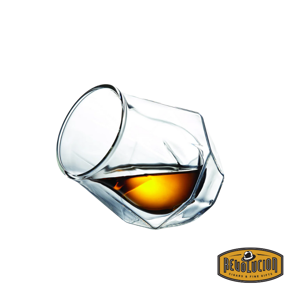 A Diamond Double Wall Whisky Glass tilted to the side, partially filled with golden whisky, highlighting its sleek, geometric design and double-wall insulation.