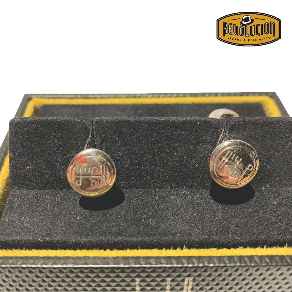 Close-up view of Dunhill cufflinks featuring the iconic Dunhill logo, highlighting the engraved symbols with a polished metallic finish.