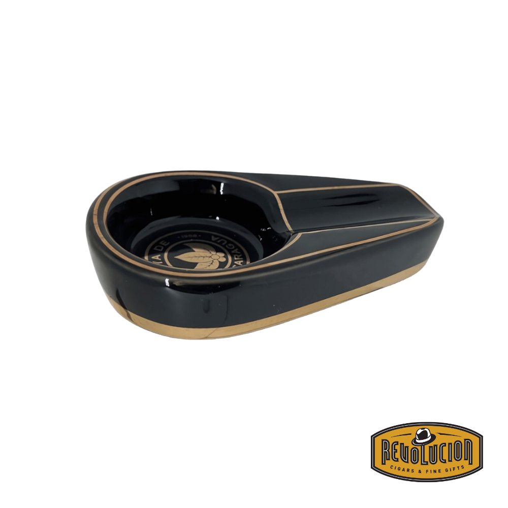 Joya de Nicaragua Mini Ashtray in sleek black with gold accents, featuring a single cigar rest and deep basin, displayed with the Revolucion Cigars &amp; Fine Gifts logo.