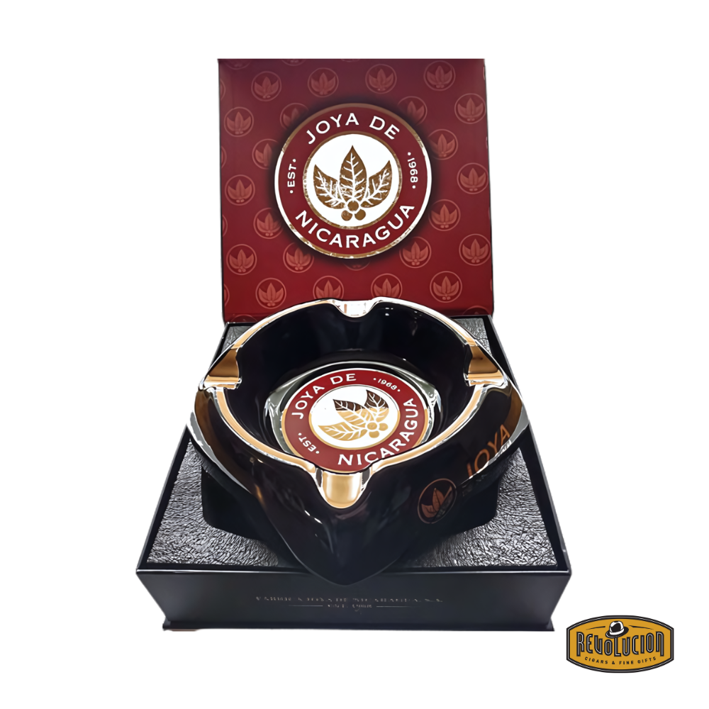 op view of the Joya de Nicaragua Gift Ashtray, featuring a bold black design with gold and red accents, and the iconic Joya de Nicaragua logo, displayed with the Revolucion Cigars & Fine Gifts logo.