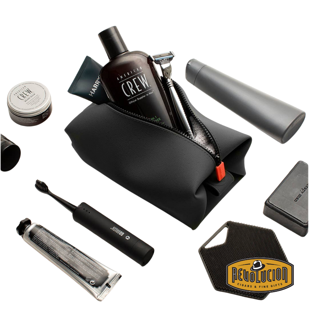 The charcoal Koby Bag placed on a bathroom sink next to grooming products, showing its practical use in a daily routine setting.