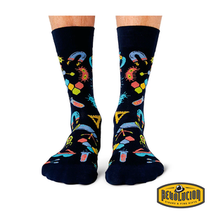 Front view of black socks featuring colorful science-themed graphics including test tubes, molecules, and magnifying glasses. The socks are branded with the Revolucion Cigars & Fine Gifts logo