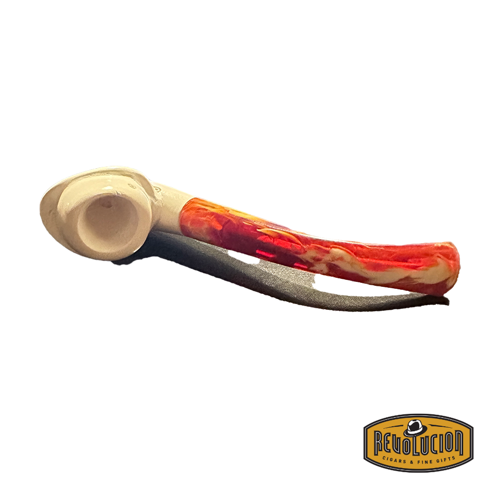 Top view of a Meerschaum pipe featuring a cream-colored bowl with a smooth finish and a vibrant red marbled stem. The pipe is resting on a dark surface.