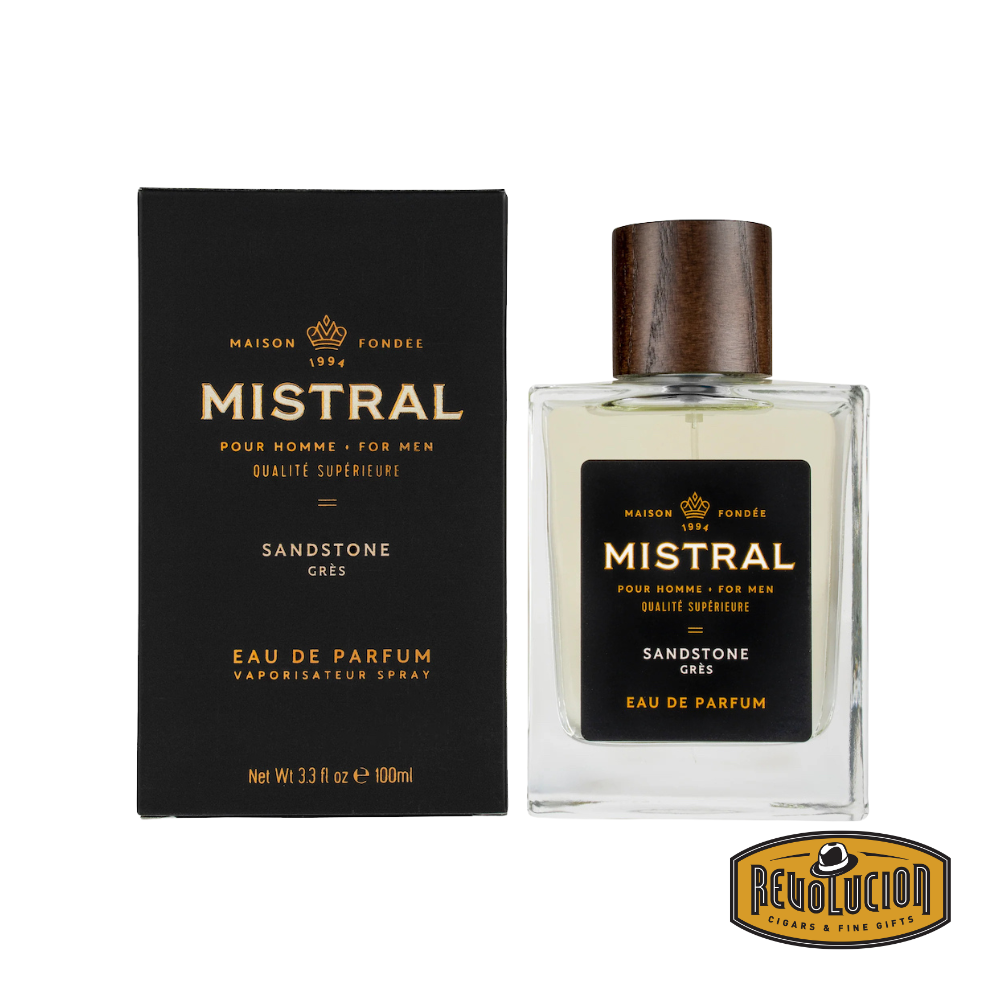 Mistral Sandstone Eau De Parfum – A sophisticated men’s fragrance with warm, earthy notes, housed in an elegant glass bottle with a dark wood cap, accompanied by a sleek black packaging.