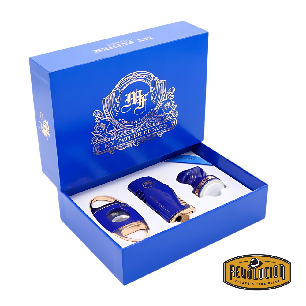 Open view of the My Father 3-Piece Gift Set in Blue, showcasing the cigar cutter, triple-torch lighter, and ceramic cigar holder, all neatly arranged in a luxurious blue box with gold detailing, displayed with the Revolucion Cigars & Fine Gifts logo.