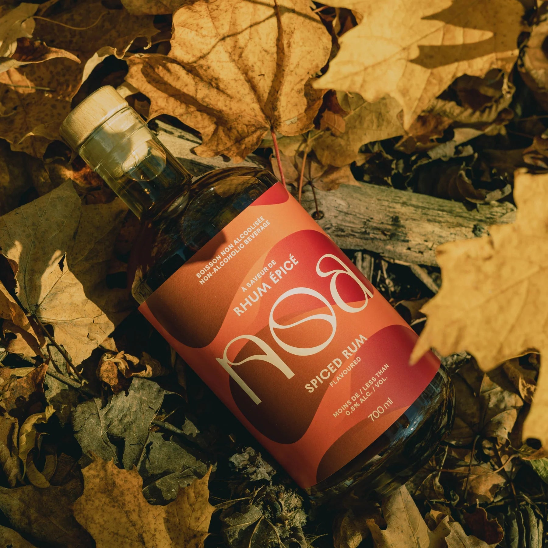 NOA Spiced Rum Non-Alcoholic 700 ml bottle set against a leafy background.