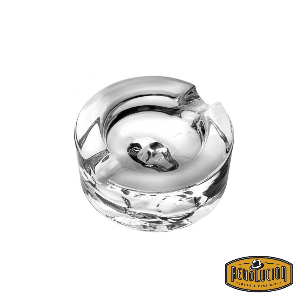 Sophisticated crystal ashtray featuring a detailed skull design embedded in the center, combining elegance and edginess. Includes the Revolucion Cigars & Fine Gifts logo