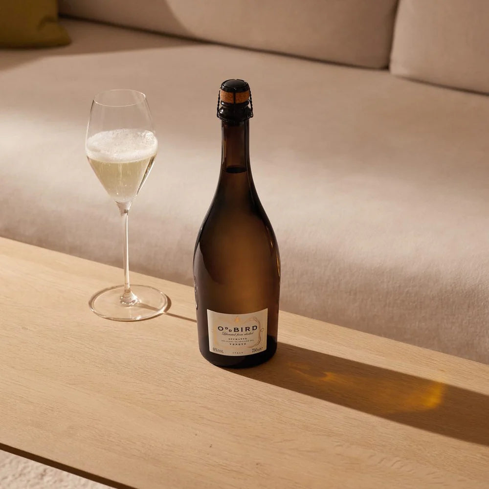 Oddbird Spumante Veneto bottle served in a flute glass, showcasing its golden bubbles and festive presentation.