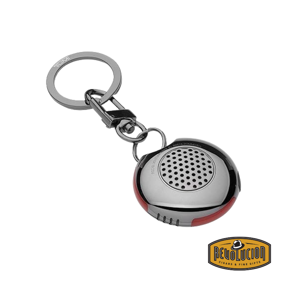 Tumi Smart Luggage Tracker device showing sleek compact design with button and branding visible.