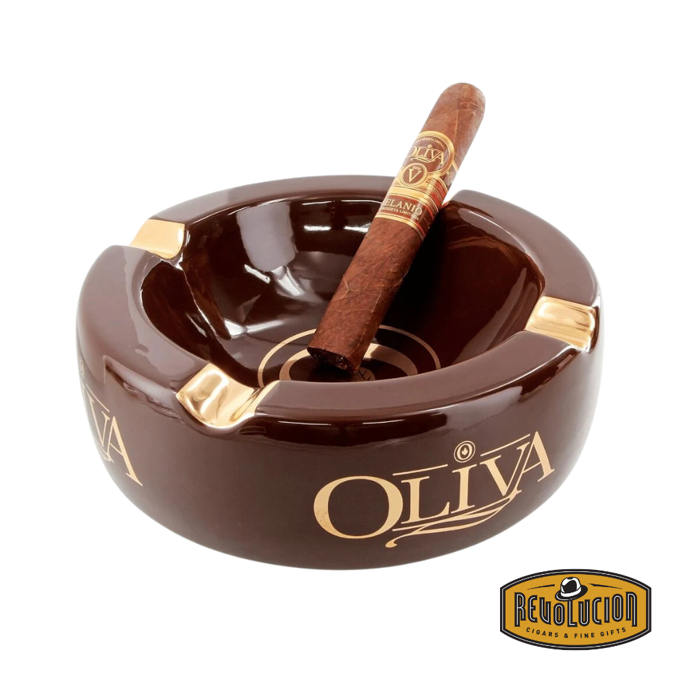 Oliva Round Ashtray in Gold/Brown, featuring a rich brown finish with gold accents, four cigar grooves, and the iconic Oliva logo, displayed with a cigar and the Revolucion Cigars &amp; Fine Gifts logo.