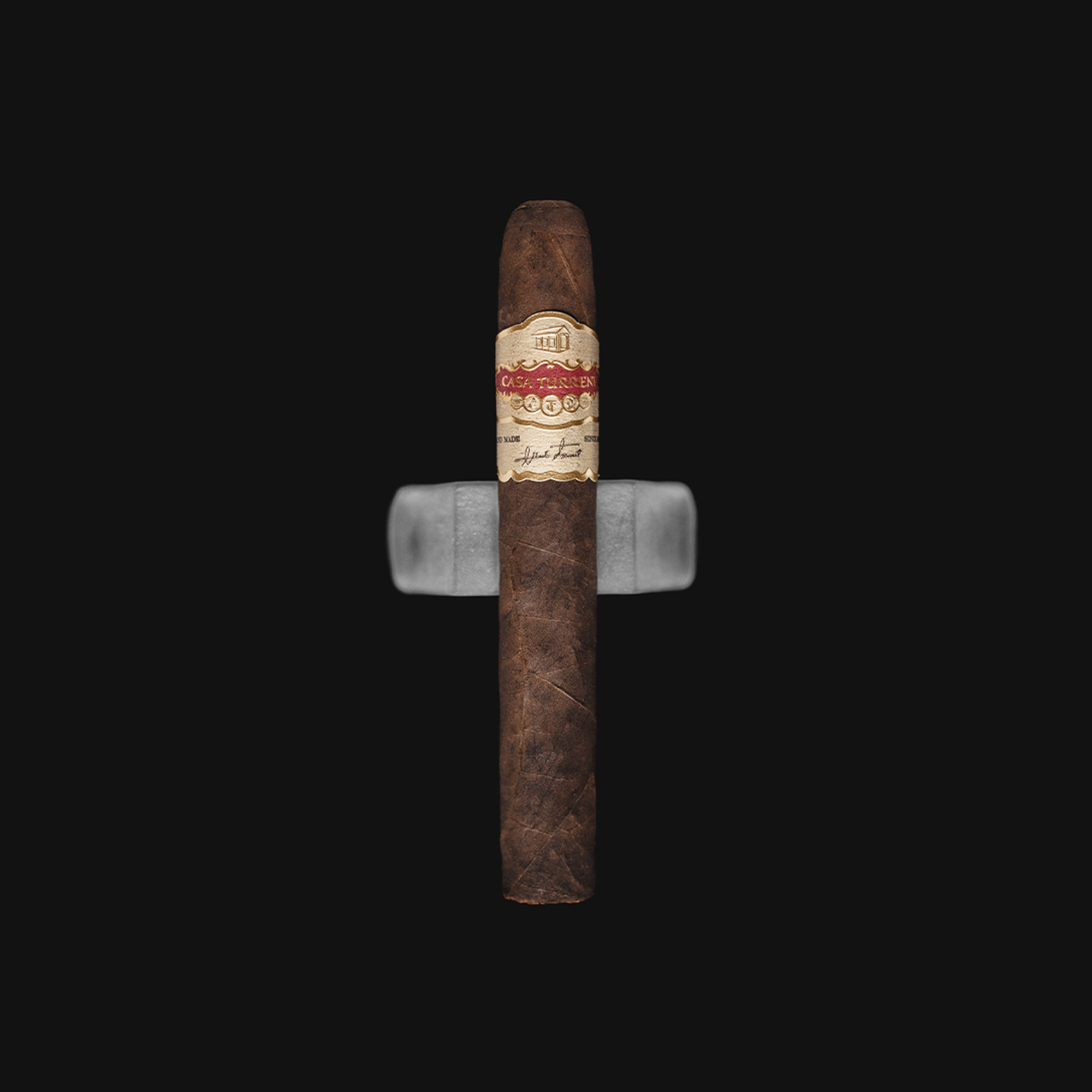 Casa Turrent 1901 Gran Robusto Medium Strength Mexican Cigar shown on a white background with a rustic wooden base, emphasizing the dark, oily wrapper and elegant band.