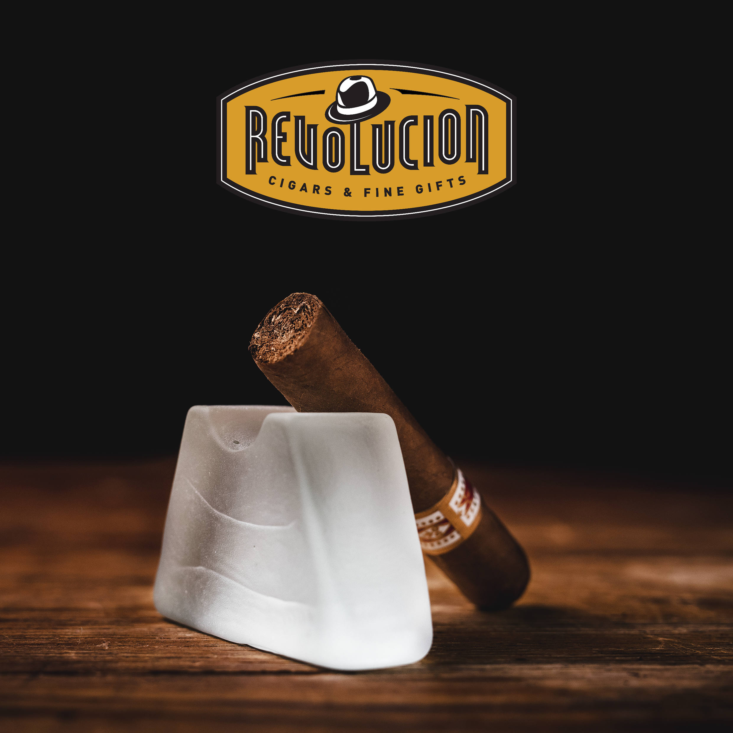 H. Upmann Half Corona Cuban cigar with a red and gold band, resting on a dark background.