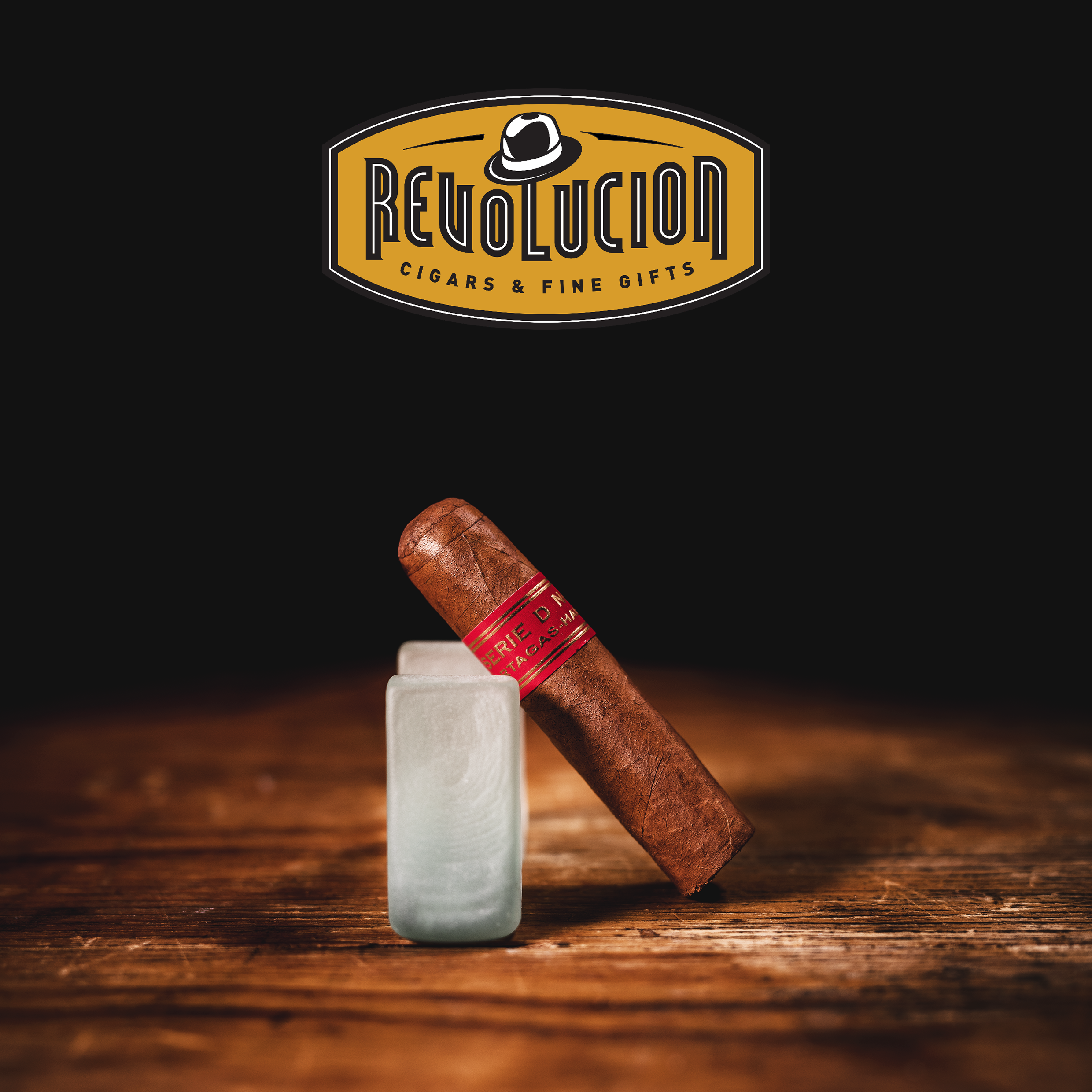 Partagás Serie D No. 6 Cuban cigar with a red band, placed on a Glass object with a dark background.