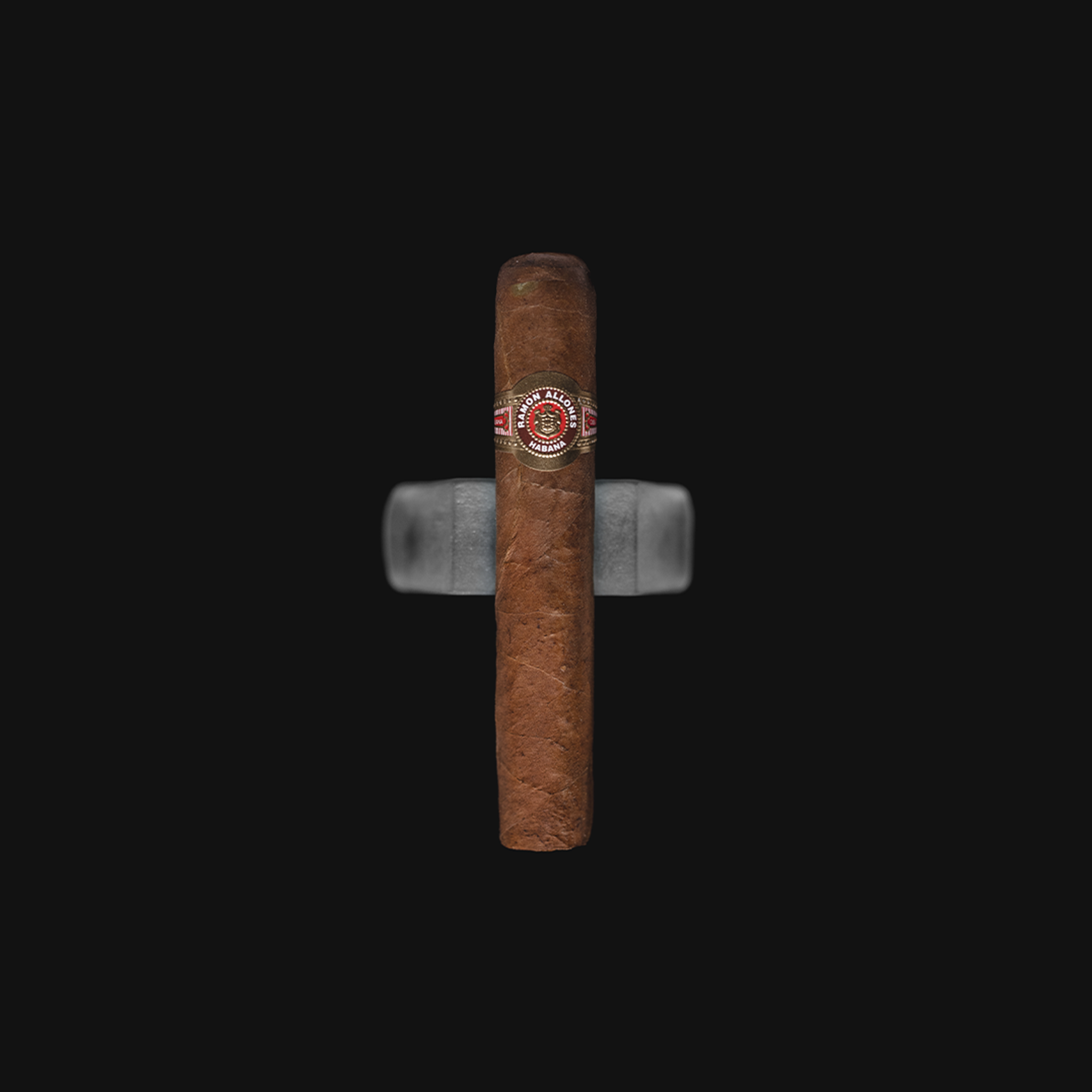 A Ramon Allones Specially Selected Cuban cigar resting on a dark background.